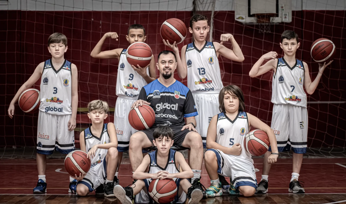 Equipe de base da AJOBB em quadra com o técnico